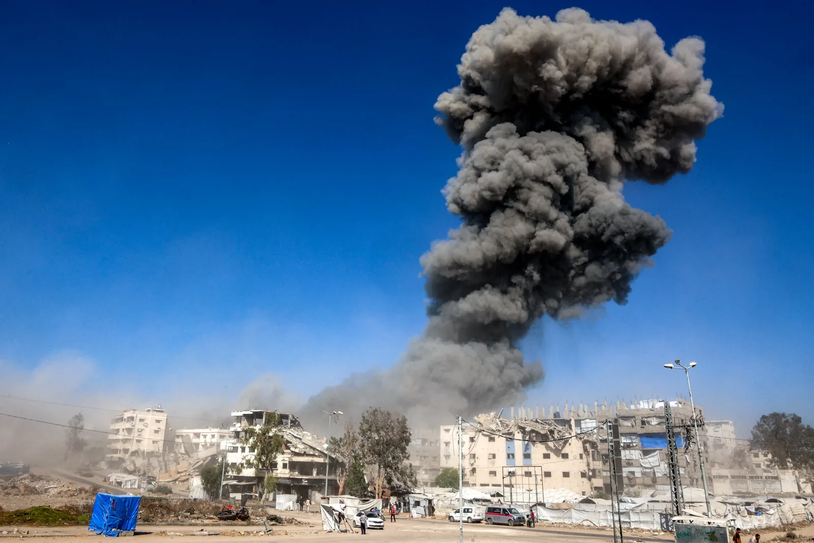 Fum dens se ridică deasupra clădirilor distruse în Gaza.