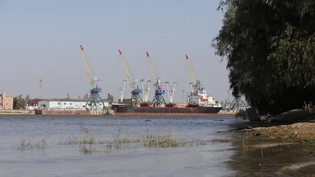 Vedere asupra portului fluvial din zona Chilia, cu macarale în fundal.