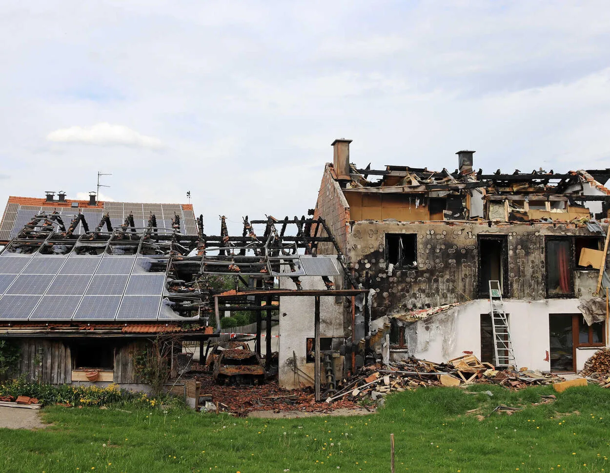 O clădire parțial distrusă de incendiu, cu panouri fotovoltaice pe acoperiș.