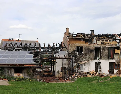 O clădire parțial distrusă de incendiu, cu panouri fotovoltaice pe acoperiș.