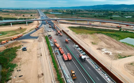 Lucrări pe Autostrada A7, cu utilaje și drum în construcție.