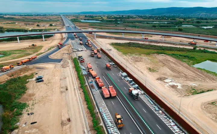 Lucrări pe Autostrada A7, cu utilaje și drum în construcție.