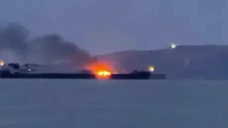 Nave în flacări pe fundalul mării, indicând atacuri navale recente.