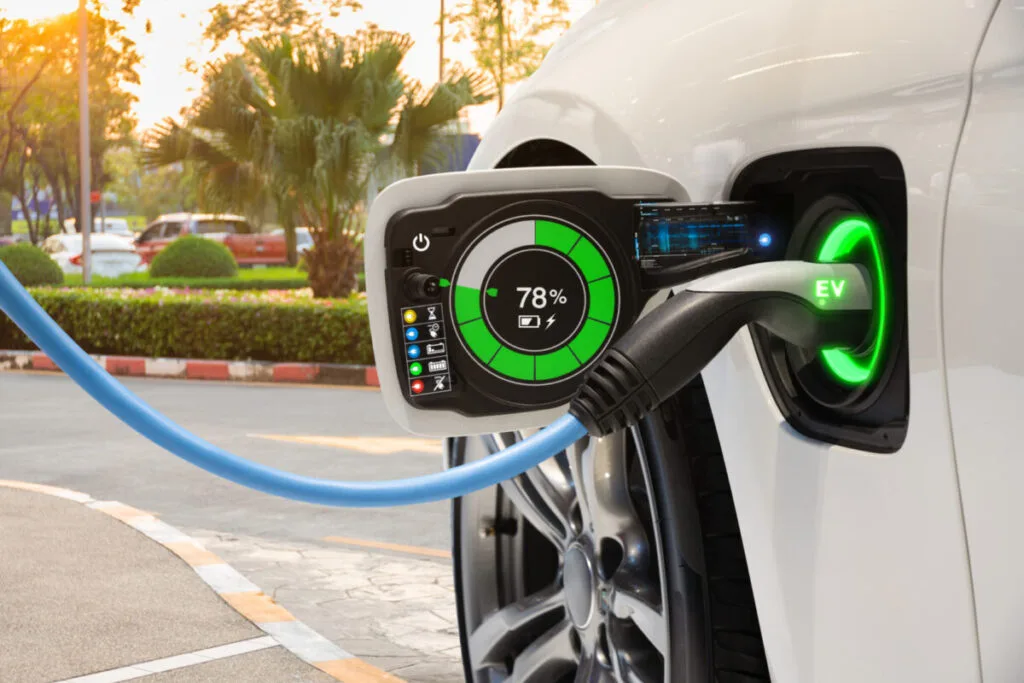 Încărcare de vehicul electric într-o stație modernă, cu indicator de baterie.