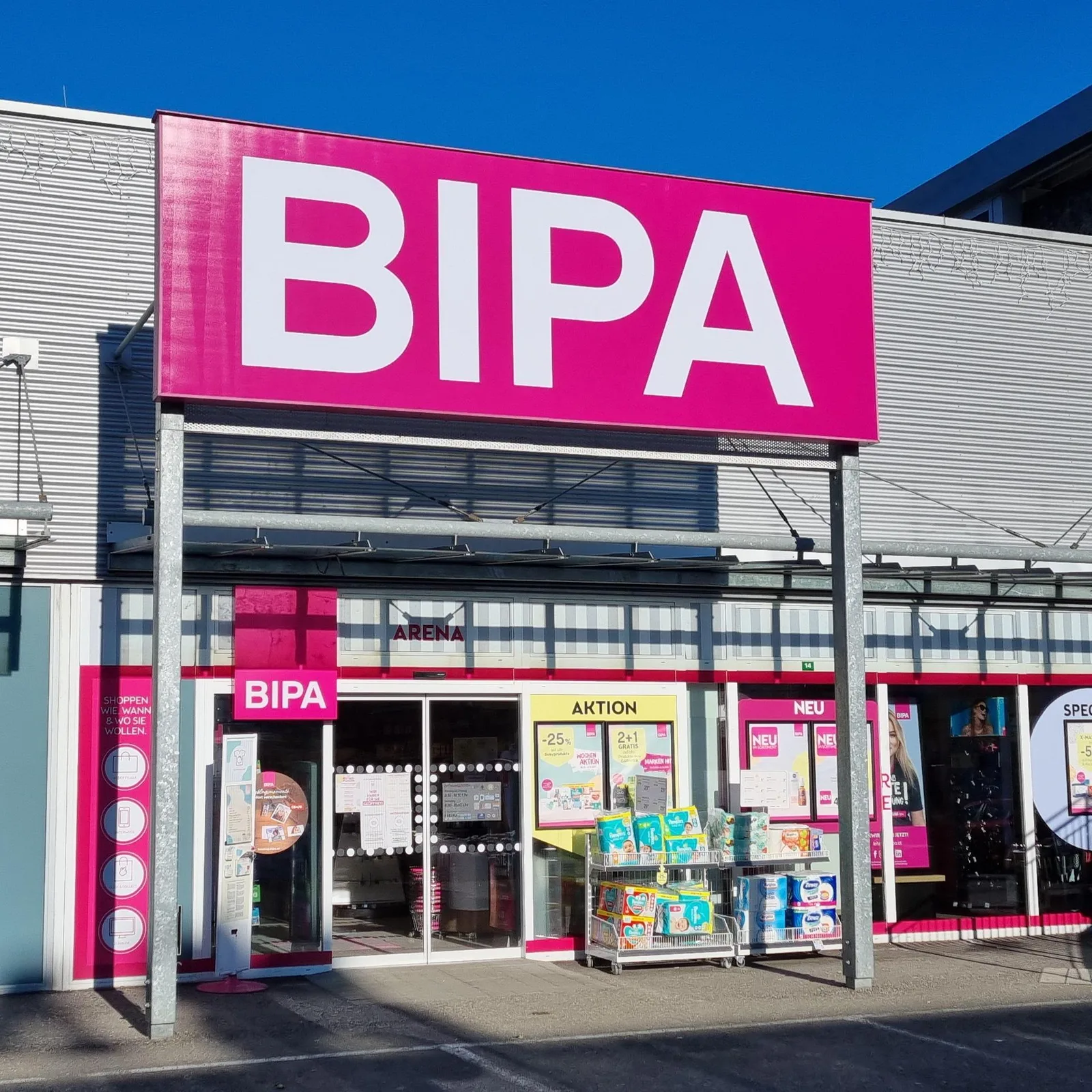 Magazin BIPA cu fațadă roz și produse expuse la intrare.