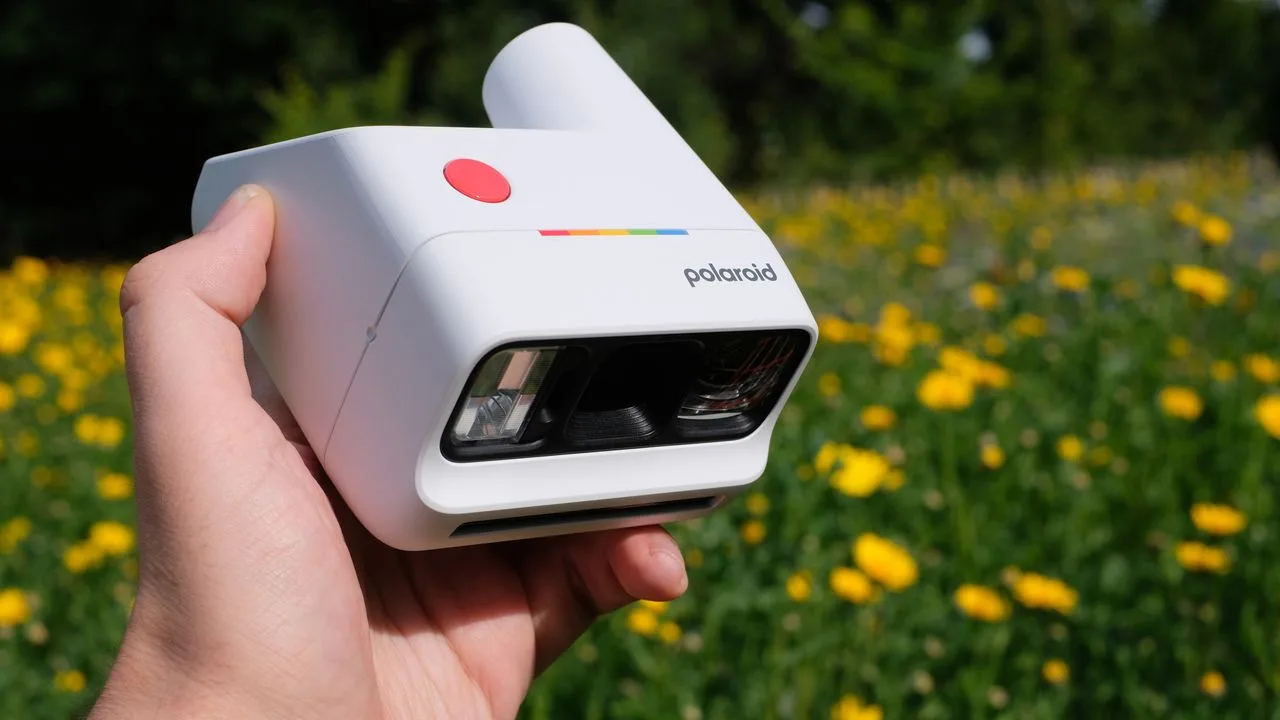 Cameră Polaroid Go Gen 3 utilizată într-un peisaj cu flori galbene.