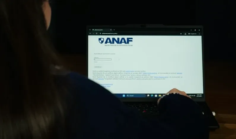 Persoană utilizând un laptop pentru a accesa site-ul ANAF.