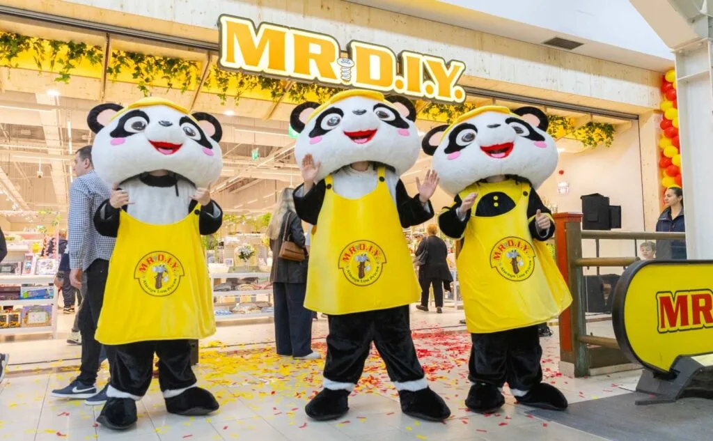 Trei mascote panda salută vizitatorii la deschiderea magazinului MR.DIY.