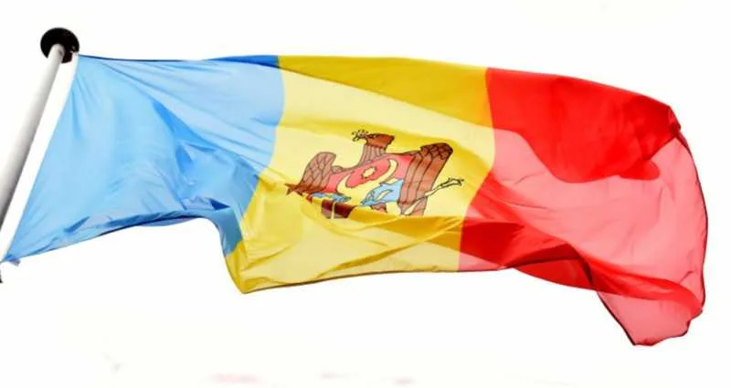 Steagul Republicii Moldova fluturând în vânt, simbol al națiunii.