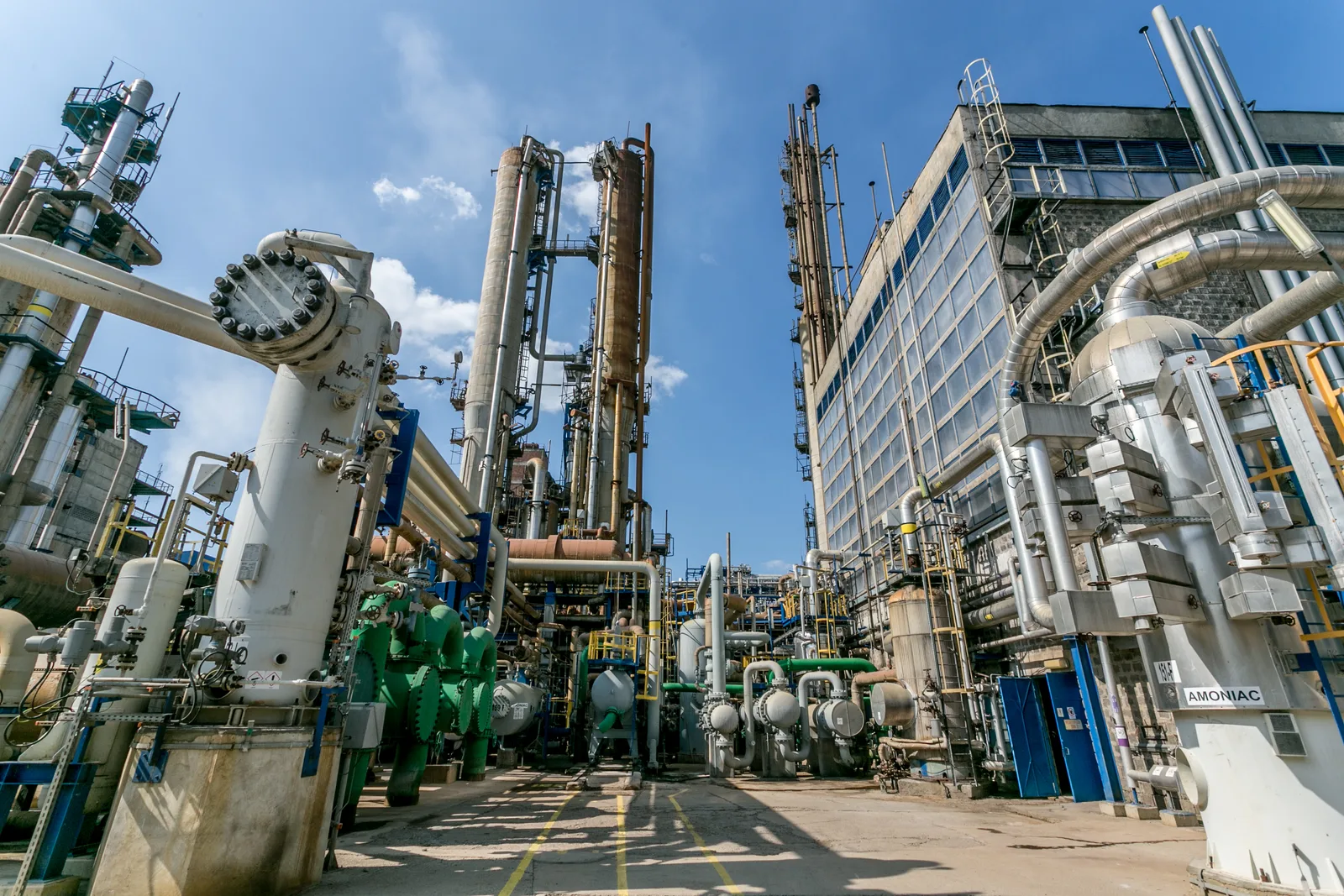 Instalație industrială complexă, cu echipamente de procesare și conducte vizibile.