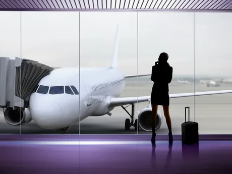 O persoană așteaptă lângă un avion într-un aeroport modern.