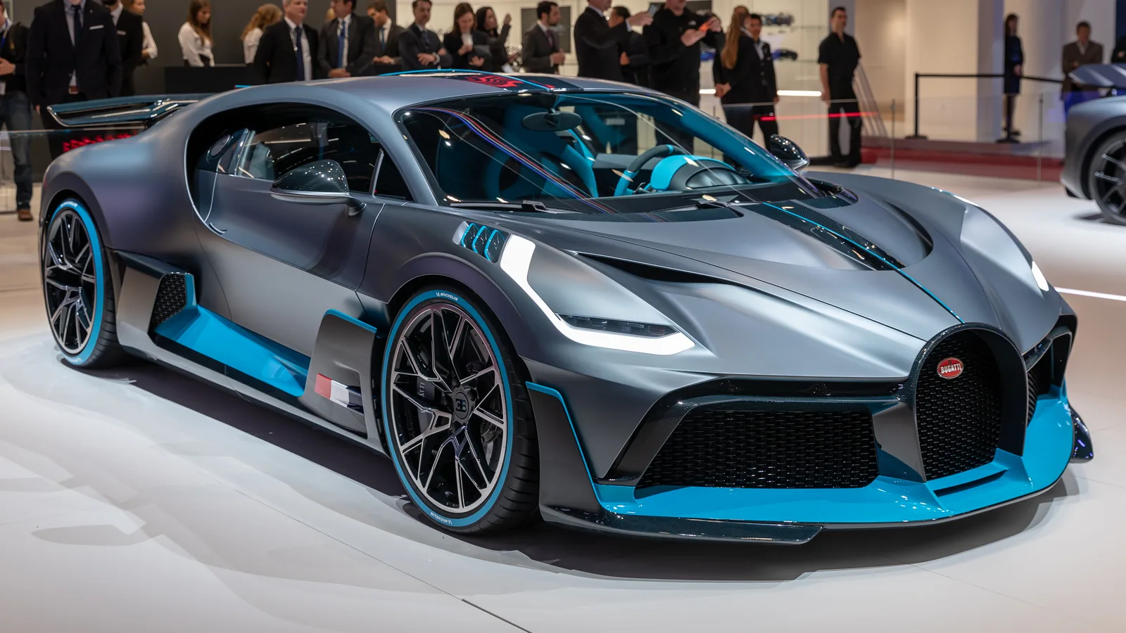 Un hypercar Bugatti expus la un eveniment auto, cu un design sofisticat și detalii elegante.