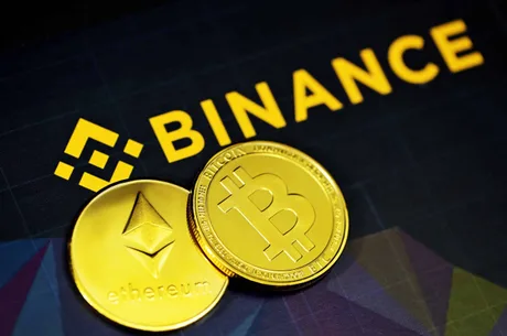 Monede digitale pe fundalul logo-ului Binance, simbolizând volatilitatea pieței crypto.