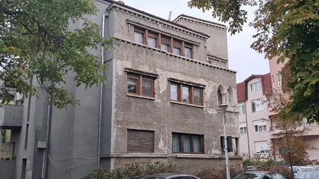 Clădire veche cu feronerie și detalii arhitecturale interesante în cartier urban.