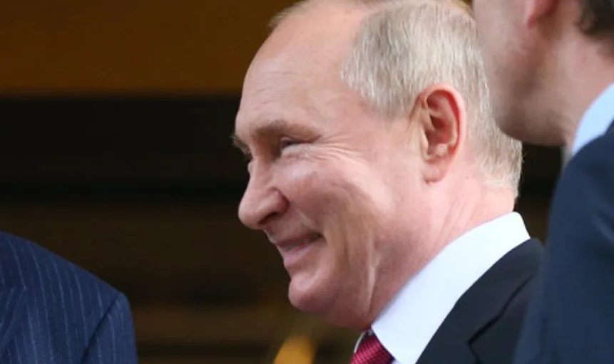 Vladimir Putin zâmbind în timpul unei întâlniri oficiale.