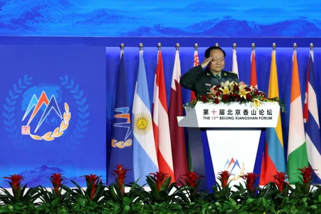 General chinez la un forum internațional, salutând participanții.