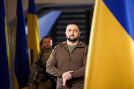 Volodimir Zelenski discutând despre situația din Ucraina în fața drapelului național.