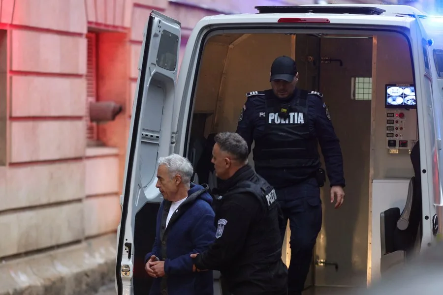 Călin Georgescu este escortat de poliție în fața tribunalului.