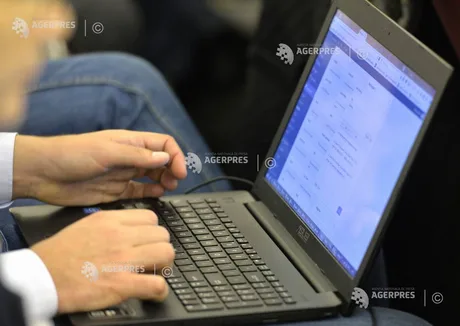 Persoană utilizând un laptop pentru a verifica informații online.