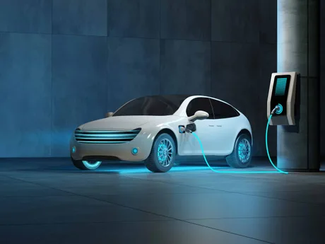 Mașină electrică conectată la un punct de încărcare într-un mediu modern.