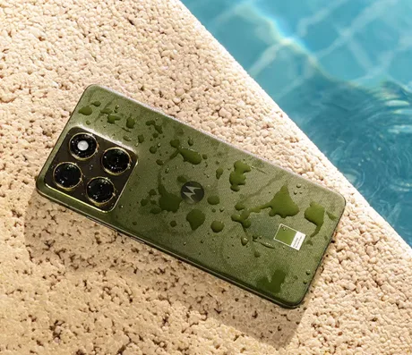 Un smartphone Motorola cu un design elegant, așezat pe o suprafață umedă.
