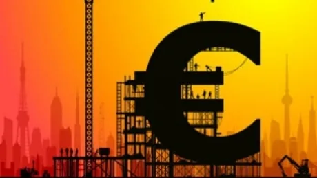 Simbolul euro pe fundalul unei construcții moderne și al unui apus vibrant.