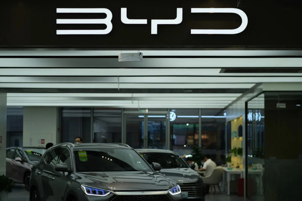 Showroom auto cu modele hibride plug-in și logo BYD vizibil
