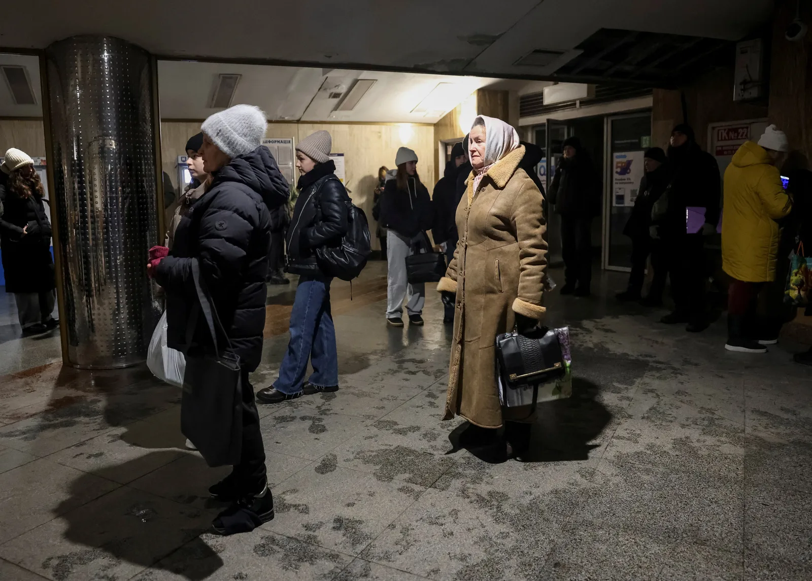 Oameni așteptând în stația de metrou în condiții dificile.