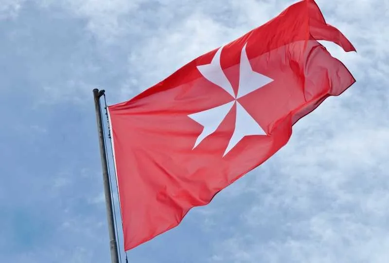 Steagul Ordinului Suveran Militar de Malta fluturând în vânt.