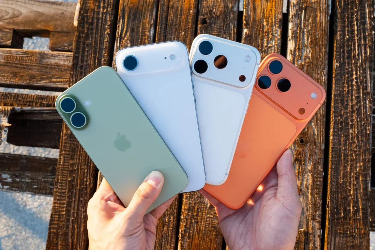 Patru modele de iPhone prezentate pe o masă din lemn.