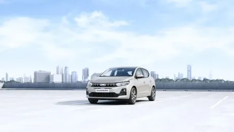 Dacia Sandero Hybrid 155 parcând pe un fundal urban modern.