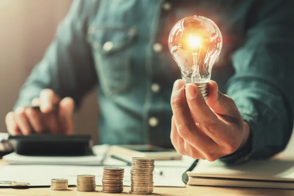 O persoană ține o bulă de energie în mână, simbolizând eficiența energetică.