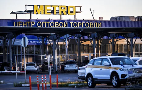 Centru de comerț Metro AG în Rusia, cu mașini parcate în față.