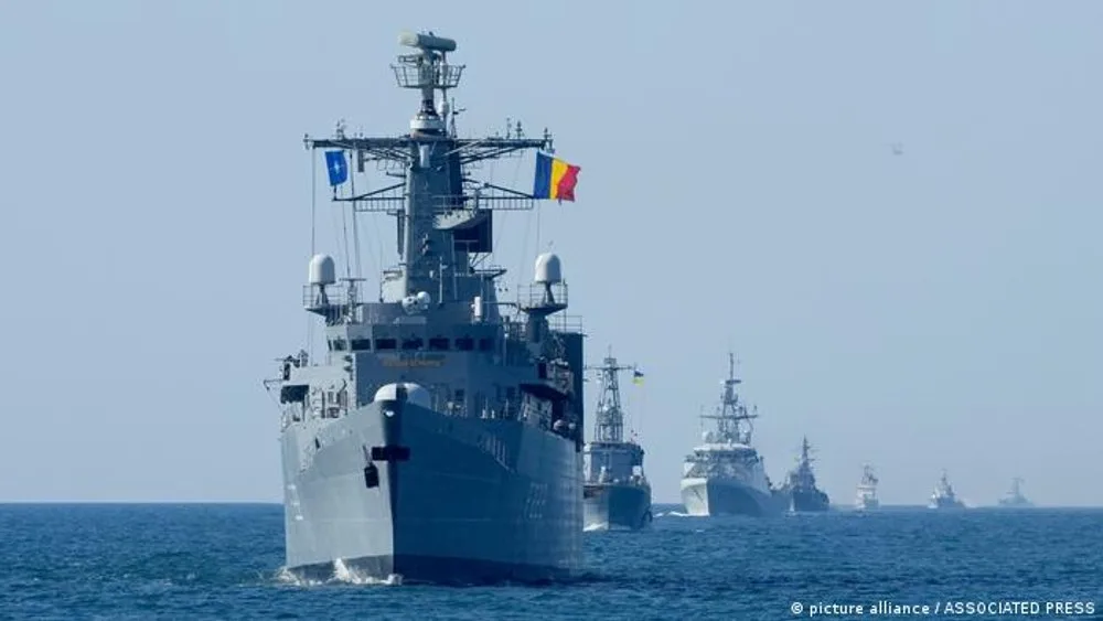 Nave militare în exercițiu pe mare, simbolizând cooperarea internațională.