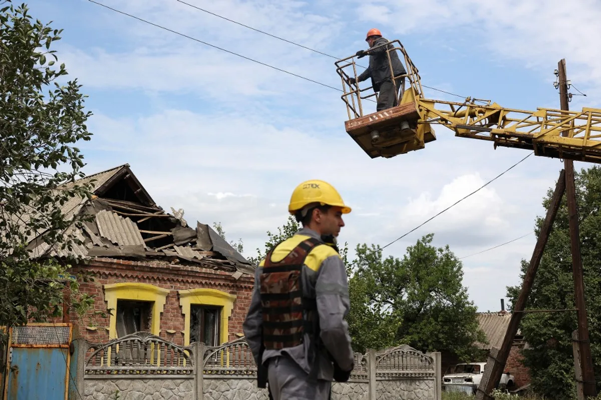 Lucrători inspectând infrastructura energetică avariată în Ucraina.