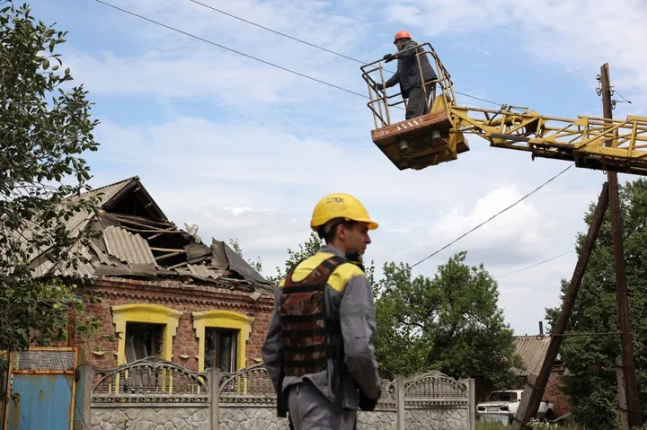 Lucrători inspectând infrastructura energetică avariată în Ucraina.