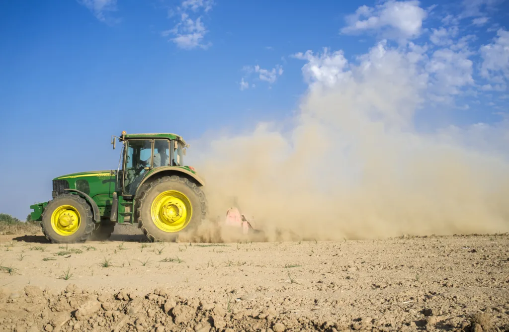 Tractor pe un câmp uscat, semn al secetei severe.