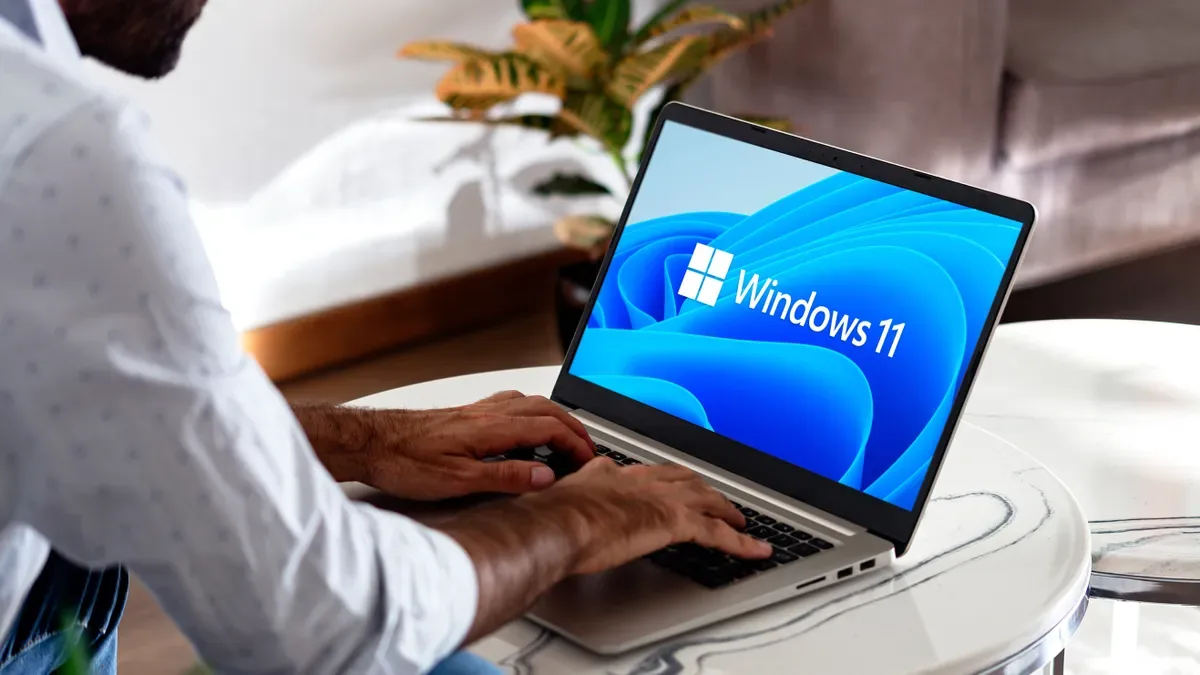 Utilizator lucrând pe un laptop cu Windows 11 deschis.