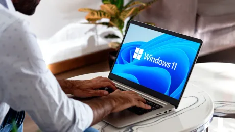 Utilizator lucrând pe un laptop cu Windows 11 deschis.