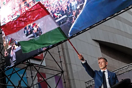 Péter Magyar susține steagul Ungariei în fața mulțimii la un eveniment public.