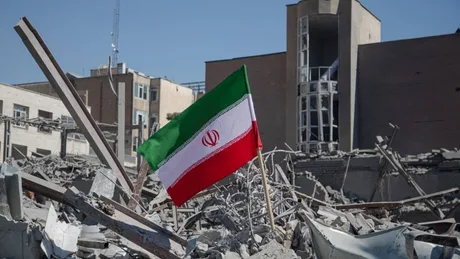 Steag iranian pe fundalul unei clădiri distruse în conflict.
