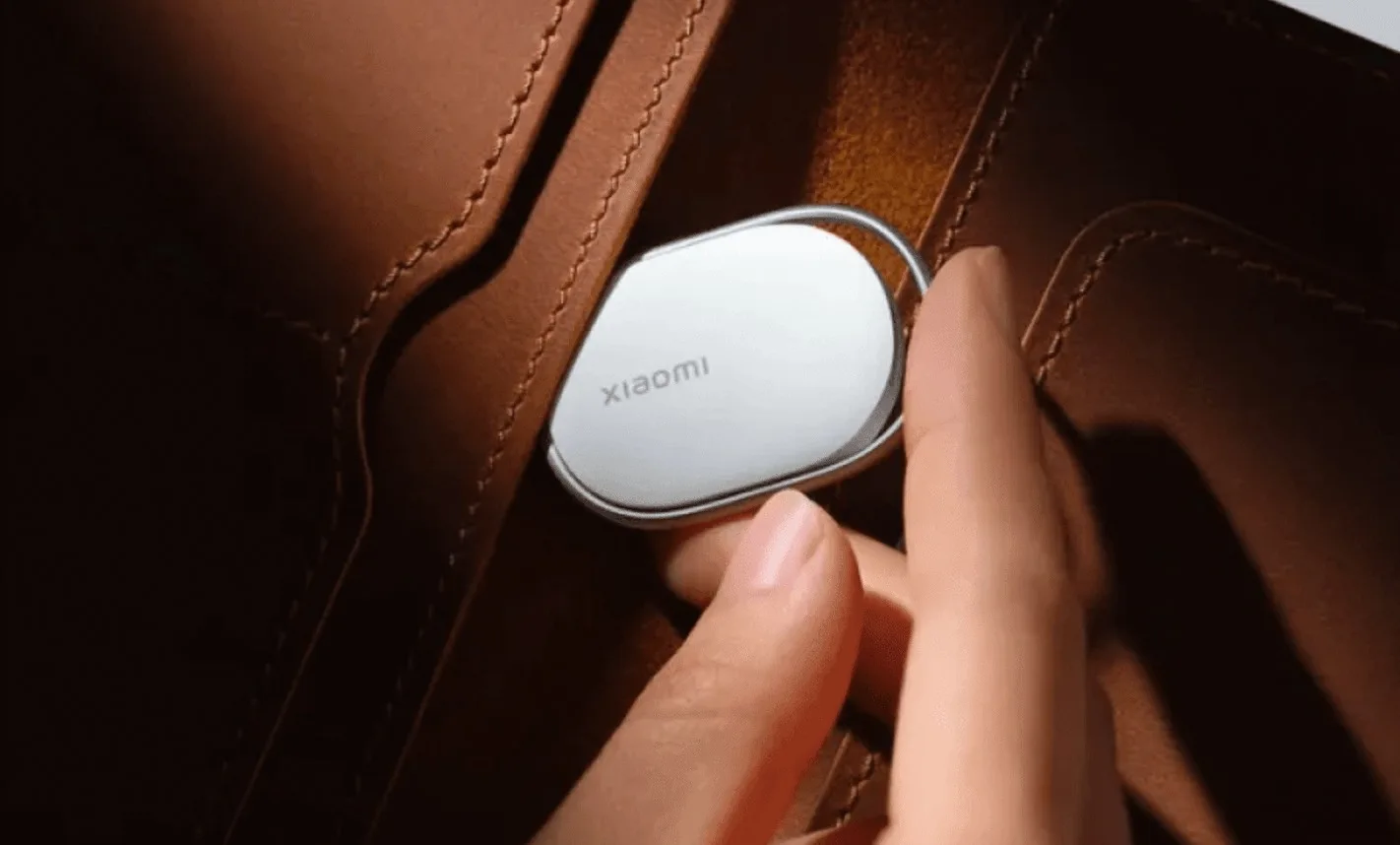 Dispozitiv de localizare Xiaomi Tag atașat la o geantă.