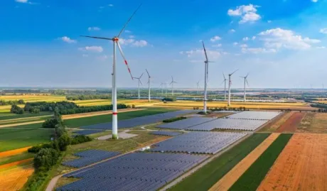 Peisaj cu turbine eoliene și panouri solare în România, evidențiind sursele de energie regenerabilă.