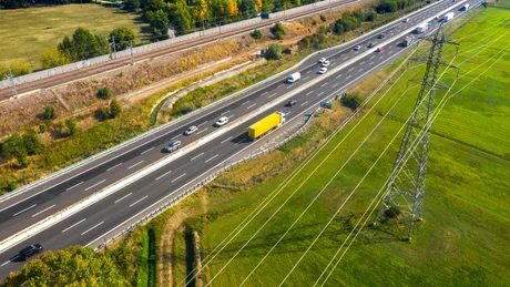 Peisaj de autostradă din Italia, cu trafic și vegetație în jur.