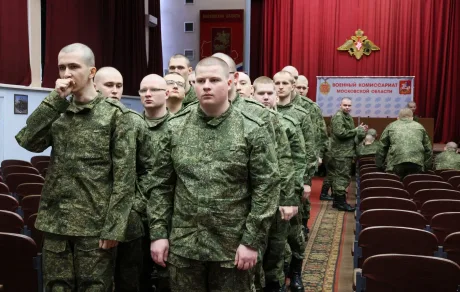 Bărbați în uniformă așteptând la comisariatul militar pentru actualizarea datelor personale.