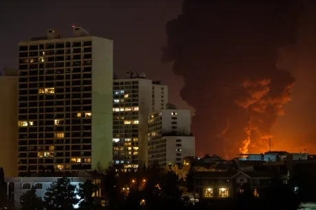 Explozie puternică în Teheran, fum și flăcări deasupra clădirilor.
