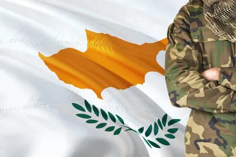Flacăra Ciprului pe fundalul unui soldat în uniformă militară.