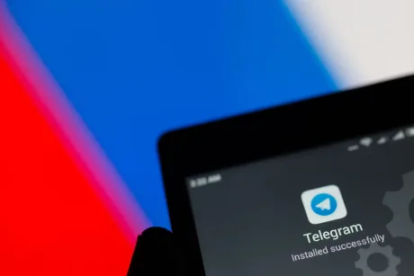 Logo-ul aplicației Telegram pe fundalul steagului Rusiei.