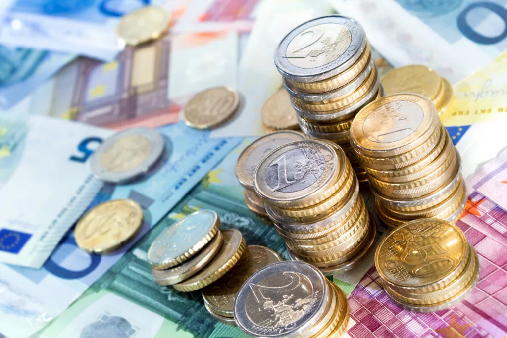 Monede și bancnote europene aranjate pe o masă.