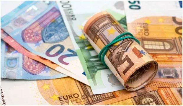 Bancnote euro aranjate pe o masă, simbolizând salariile în Uniunea Europeană.